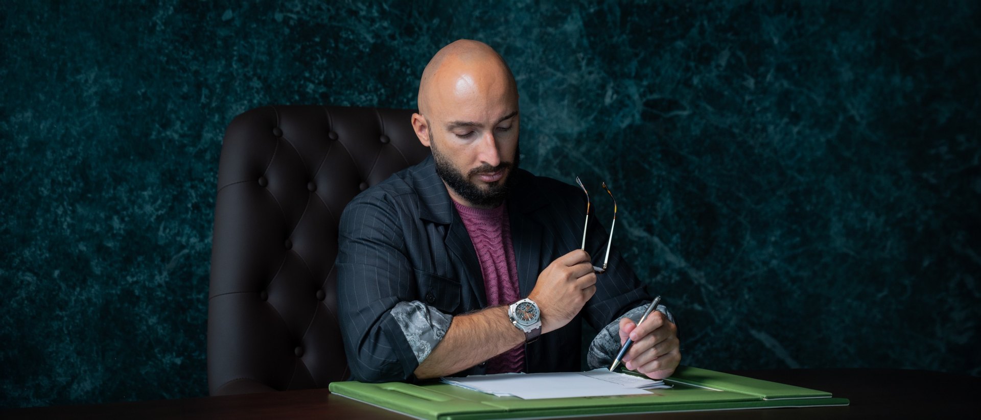 Daniele Pescara alla scrivania mentre scrive, in un ufficio dai toni scuri